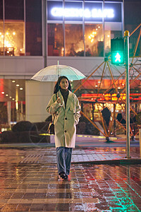下雨天撑着伞走过斑马线的女生背景图片