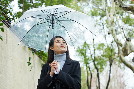 下雨天在城市里行走的女性图片
