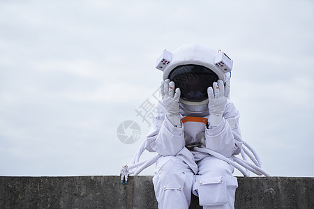 宇航员低头坐着思考背景图片