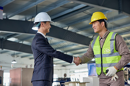 商务人士和技术工人握手图片