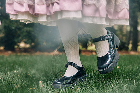 草地上的洛丽塔女孩的脚部特写背景