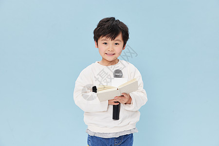 手拿话筒练习主持人发言的小男孩背景图片