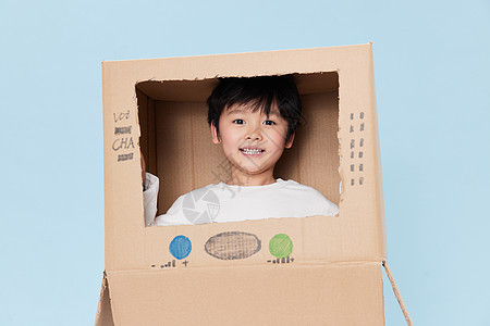 可爱小男孩与纸箱玩耍互动图片