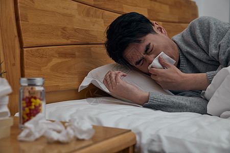 中年男性吃药患病中年男性卧床擦拭鼻涕背景