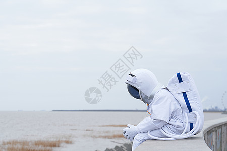 宇航员户外坐在海边思考图片