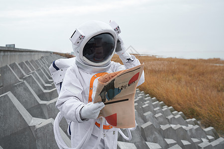 穿着宇航服的男性看报纸图片