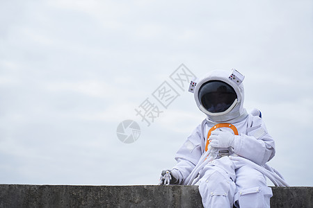 黑洞太空宇航员穿着宇航服的男性坐在海边背景