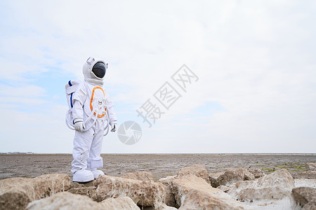 海滩边穿着宇航服的男性背景图片