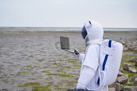 穿着宇航服的男性看笔记本图片