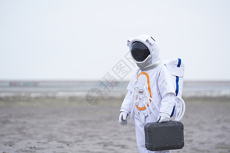太空宇航员穿着宇航服的男性拿手提箱背景