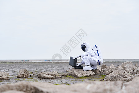 穿着宇航服的男性拿手提箱图片