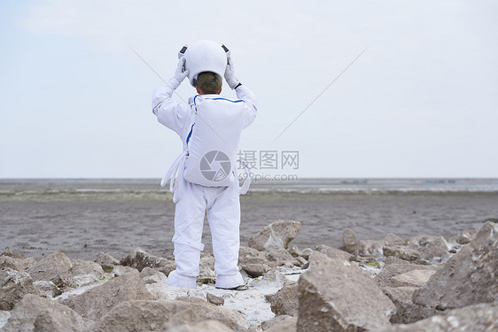 穿着宇航服的男性脱下帽子图片