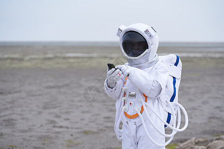 穿着宇航服的男性看手机背景图片