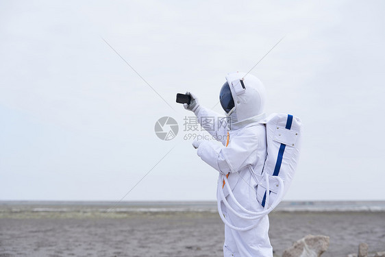 穿着宇航服的男性看手机直播图片