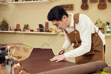 男性工匠裁切皮料皮具图片