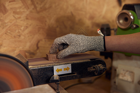 男性工匠打磨木块手部特写图片