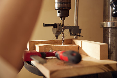男性工匠使用钻木机打孔特写图片