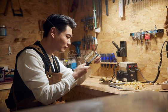 夜晚制作木块的男性工匠图片