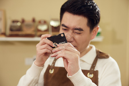 男性工匠查看戒指特写图片