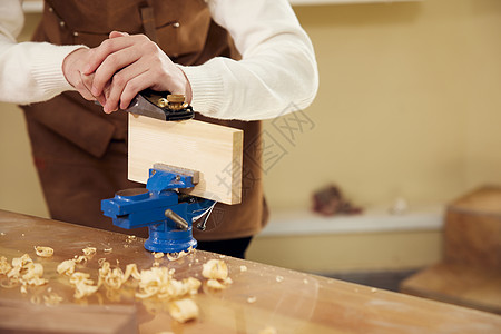 男性木匠打磨木块手部特写图片