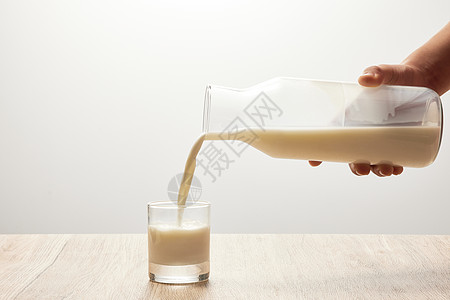 杯中窥人把牛奶从瓶子里倒在玻璃杯中背景