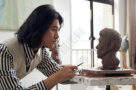 年轻文艺男青年专注雕塑形象图片