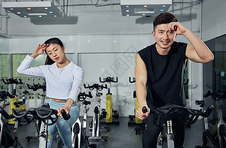健身房动感单车激烈训练的运动情侣图片