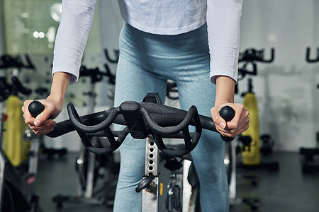 健身房私教健身房动感单车训练热身运动特写背景