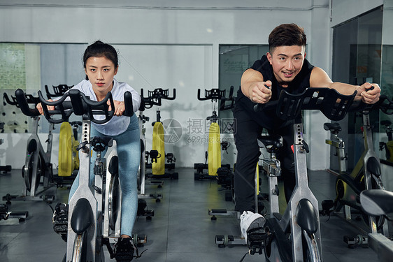 健身房动感单车训练的健身情侣图片