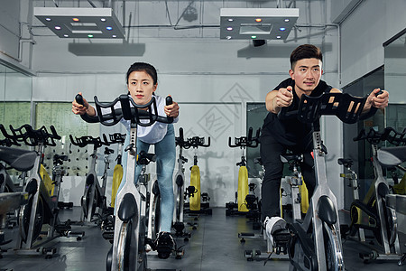 健身房动感单车训练前做热身运动的健身男女图片