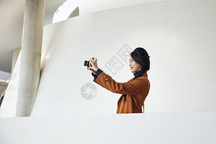 青年女性展览馆使用相机拍照记录图片
