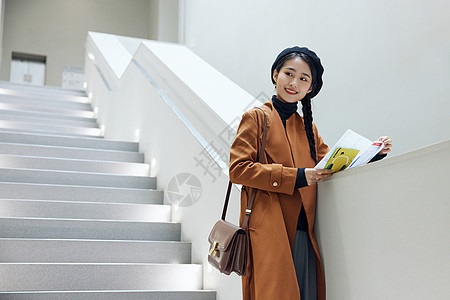 楼梯画册文艺女青年看展览画册介绍背景