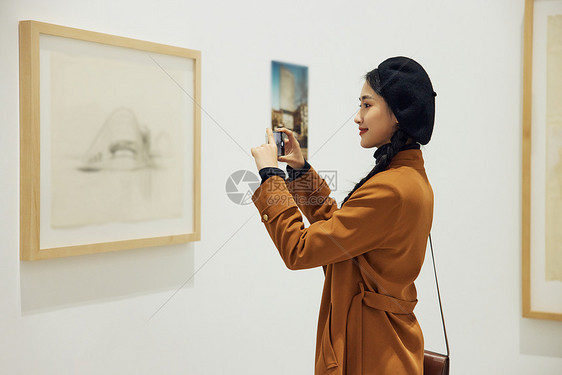 博物馆看展拍照的青年女性图片