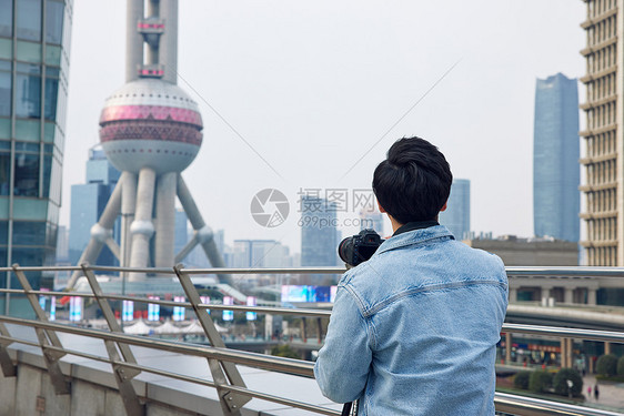 拍摄东方明珠的男摄影师背影图片