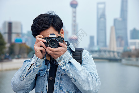 手拿相机拍摄的男摄影师形象图片素材