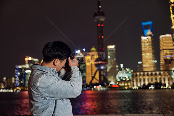 拍摄上海城市夜景的男摄影师图片