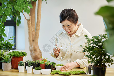 用喷壶对植物喷水的女性图片
