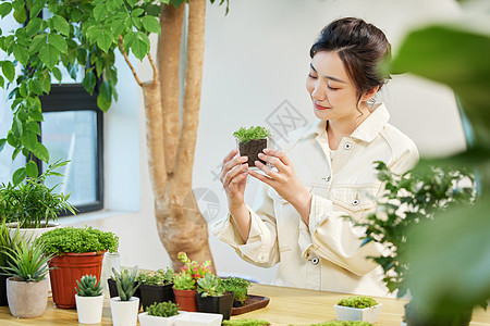 观察盆栽植物的女性图片