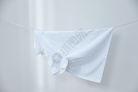 晾衣绳上晾晒着的短袖白衬衫背景图片