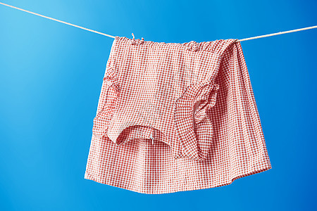 晾衣绳上晾晒着的粉色长裙图片