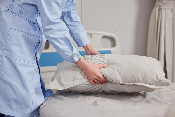 整理病床的女护士特写图片