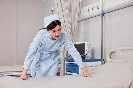 红十字 医院整理病床的女护士背景