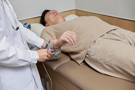 男性患者躺在病床上接受检查图片