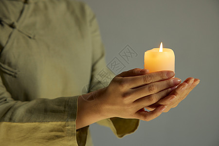 女性手捧祈福蜡烛特写图片