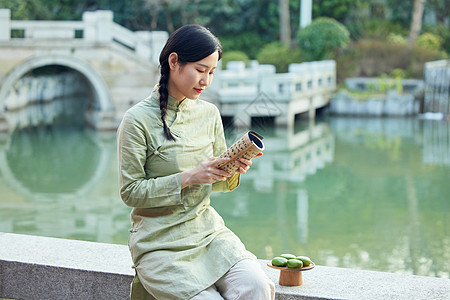 户外看书吃青团的青年美女图片