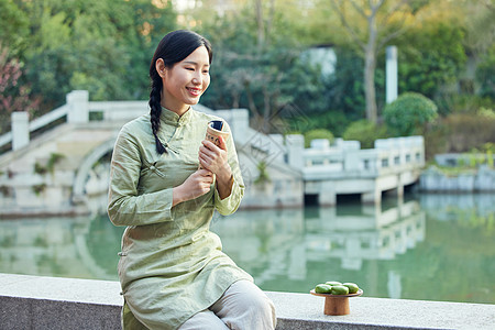 室外看书吃青团的青年女性图片