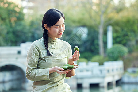 青年女性户外品尝青团图片