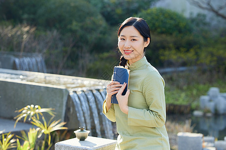 气质女性户外赏植看书背景图片