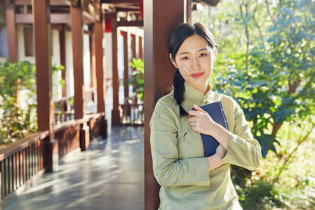 素雅美女户外赏植看书图片