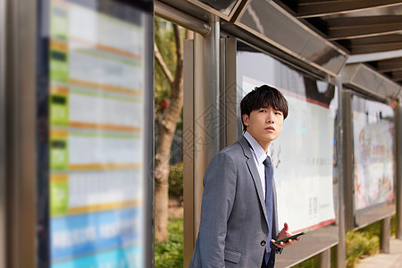 努力小白着急地等待公交车的男青年背景